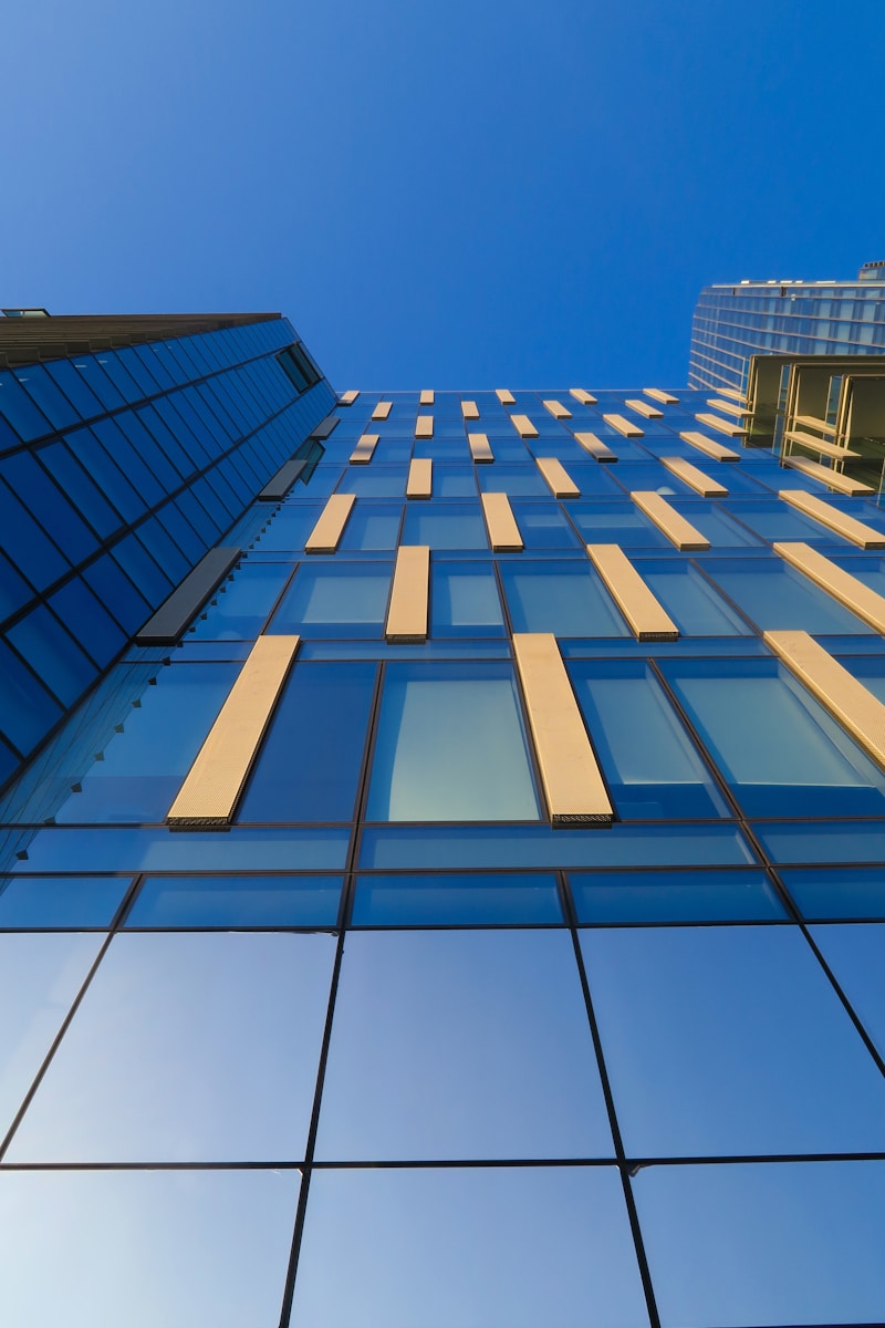 low-angle photography of blue glass building